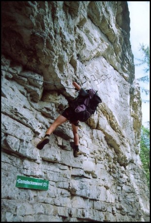 Pokračování zajištěné cesty na vápencové skále v lese.
